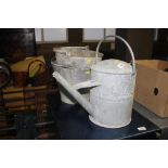 A vintage galvanised watering can; and two galvani