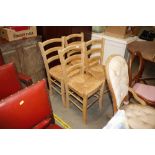 A set of four rush seated ladder back dining chairs