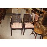 A pair of dark wood cane back elbow chairs