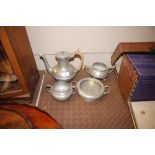 A pewter spot hammered three piece teaset; and a small twin handled bowl, similar