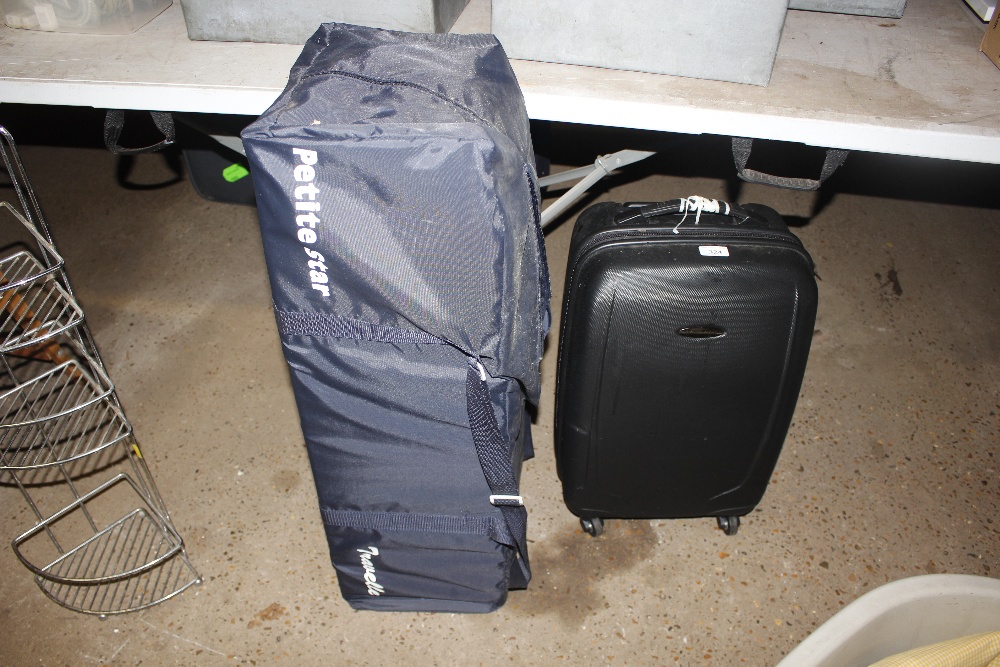 A travel cot; and a hard cased suitcase