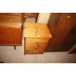 A modern stripped pine bedside chest of three draw