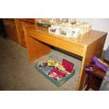 A light wood desk, fitted with three drawers