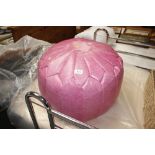 A pink faux leather pouffe