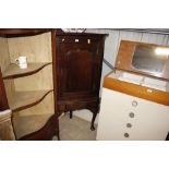 An antique oak corner cupboard on stand