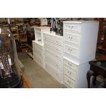 A white laminate chest of five drawers; matching c
