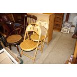 A pair of light wood folding kitchen chairs