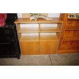 A light wood oak open fronted bookcase with cupboa