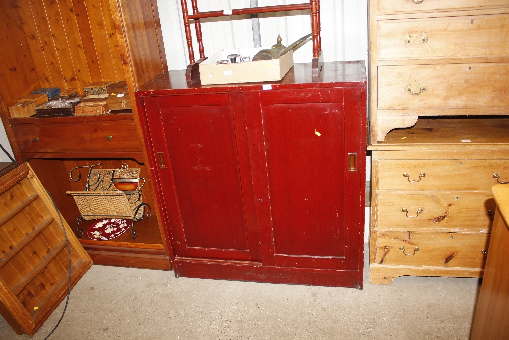 A grained pine side cupboard enclosed by sliding d