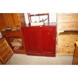 A grained pine side cupboard enclosed by sliding d