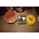 A plastic planter; a roll of hose and fittings etc