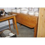 A stripped pine drop leaf kitchen table