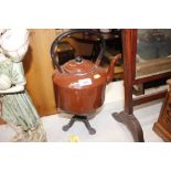 A brown enamel kettle on iron trivet