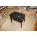 A modern black adjustable piano seat