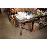 An oak drop leaf table on barley twist supports