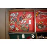 A tray of various decorative costume brooches