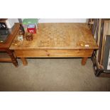 A pine coffee table with inlaid chessboard top