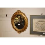 An oval gilt framed wall mirror