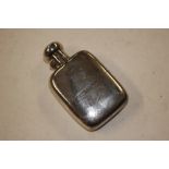 A silver hip flask with detachable cup bearing mon