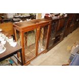 A reproduction yew wood finish display cabinet