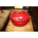 A large red glazed pottery casserole dish