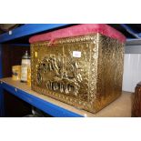 A brass embossed coal box with upholstered seat