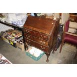 A mahogany three drawer bureau on claw and ball su