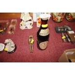 A vintage bottle of Caribbean Guinness and a pair of brass novelty nut crackers