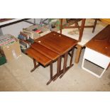 A mahogany finish nest of three coffee tables