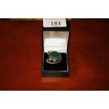 A white metal dress ring inset large green stone