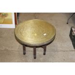 A circular Eastern brass bound coffee table on fol