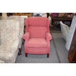 A red upholstered reclining armchair