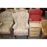 A pair of upholstered wing back armchairs