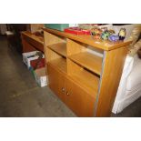 A light wood open fronted bookcase with cupboard b