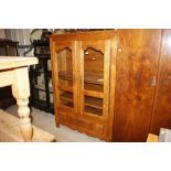A large continental oak display cabinet, enclosed