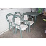 A green plastic garden table and four chairs