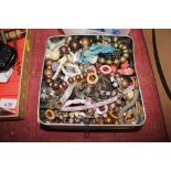 A tin containing various costume jewellery beads et