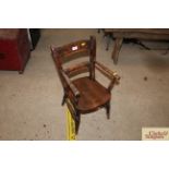 An antique child's cottage armchair in elm and bee