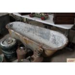 An Edwardian tin bath on cast iron feet