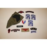 A collection of material military badges to includ