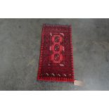 An approx. 3' x 1'7" red wool rug