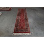 An approx. 9' x 2'3" red patterned runner