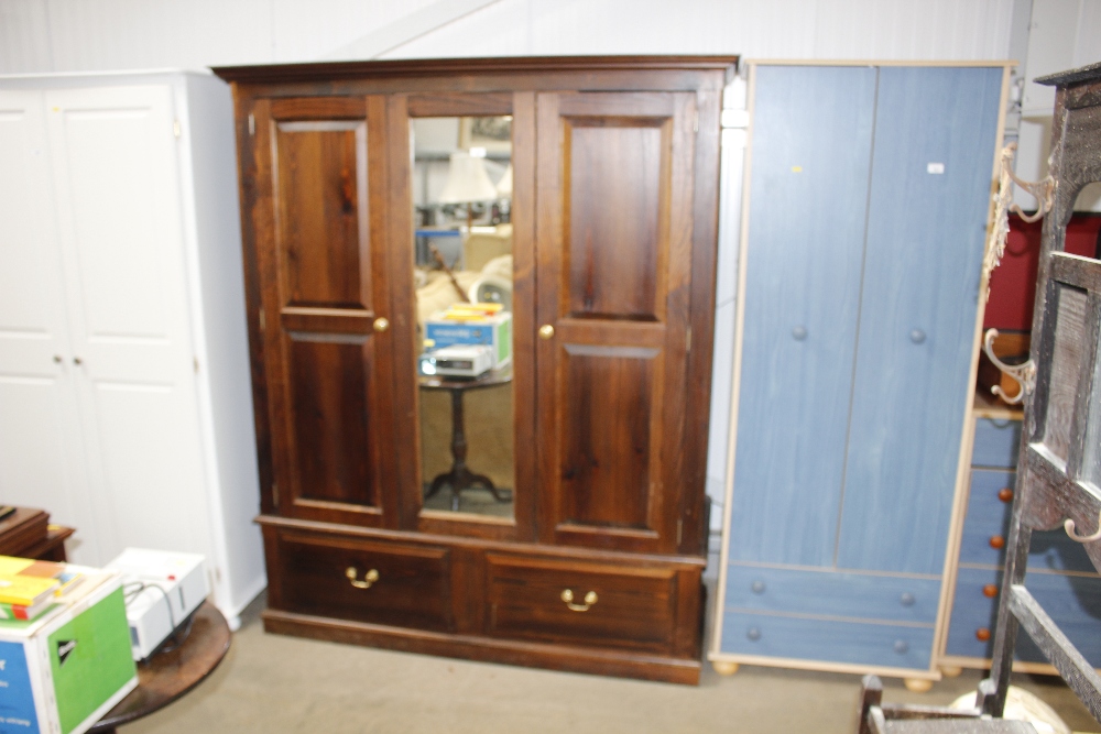 A stained pine mirrored fronted two door wardrobe