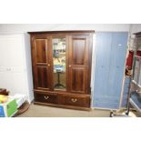 A stained pine mirrored fronted two door wardrobe