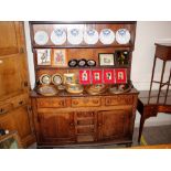 An 18th Century oak dresser, having shelved and boarded plate rack above three frieze drawers,