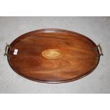 An Edwardian inlaid mahogany oval tea tray, having central conch shell patterae flanked by brass