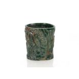 An unusual Chinese green hardstone brush pot, decorated figures in relief with six character and