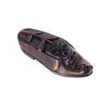 A late 19th Century carved Black Forest table shoe snuff, with hinged lid decorated with flowers and