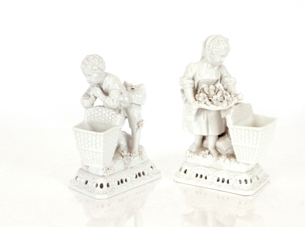 A pair of Meissen blanc de chine posy vases, in the form of children with baskets, having floral