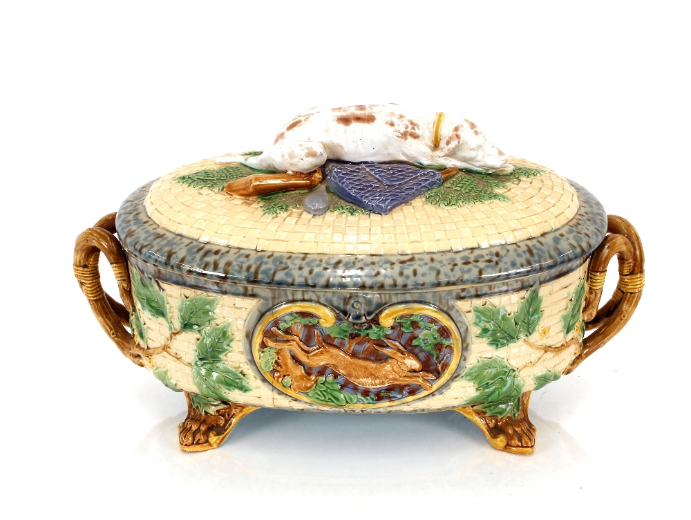 A Minton Majolica game pie dish and cover, decorated gun dog and shooting apparel to the lid, the